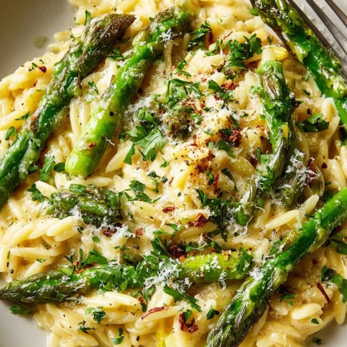 Close-up of creamy Lemon Butter Orzo with Asparagus, glistening with Parmesan and herbs.