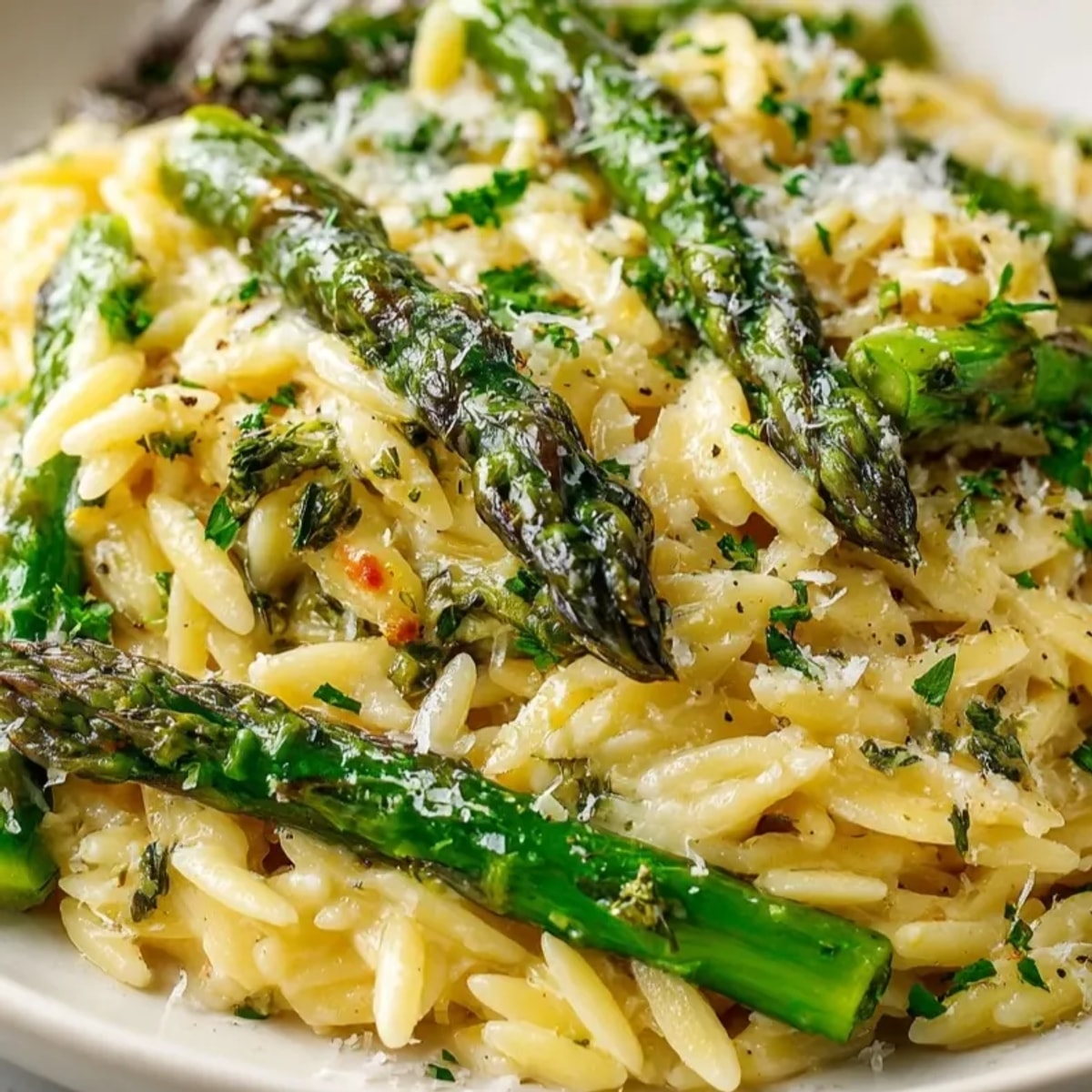Golden Lemon Butter Orzo with Asparagus swirls in a bowl, ready to eat.