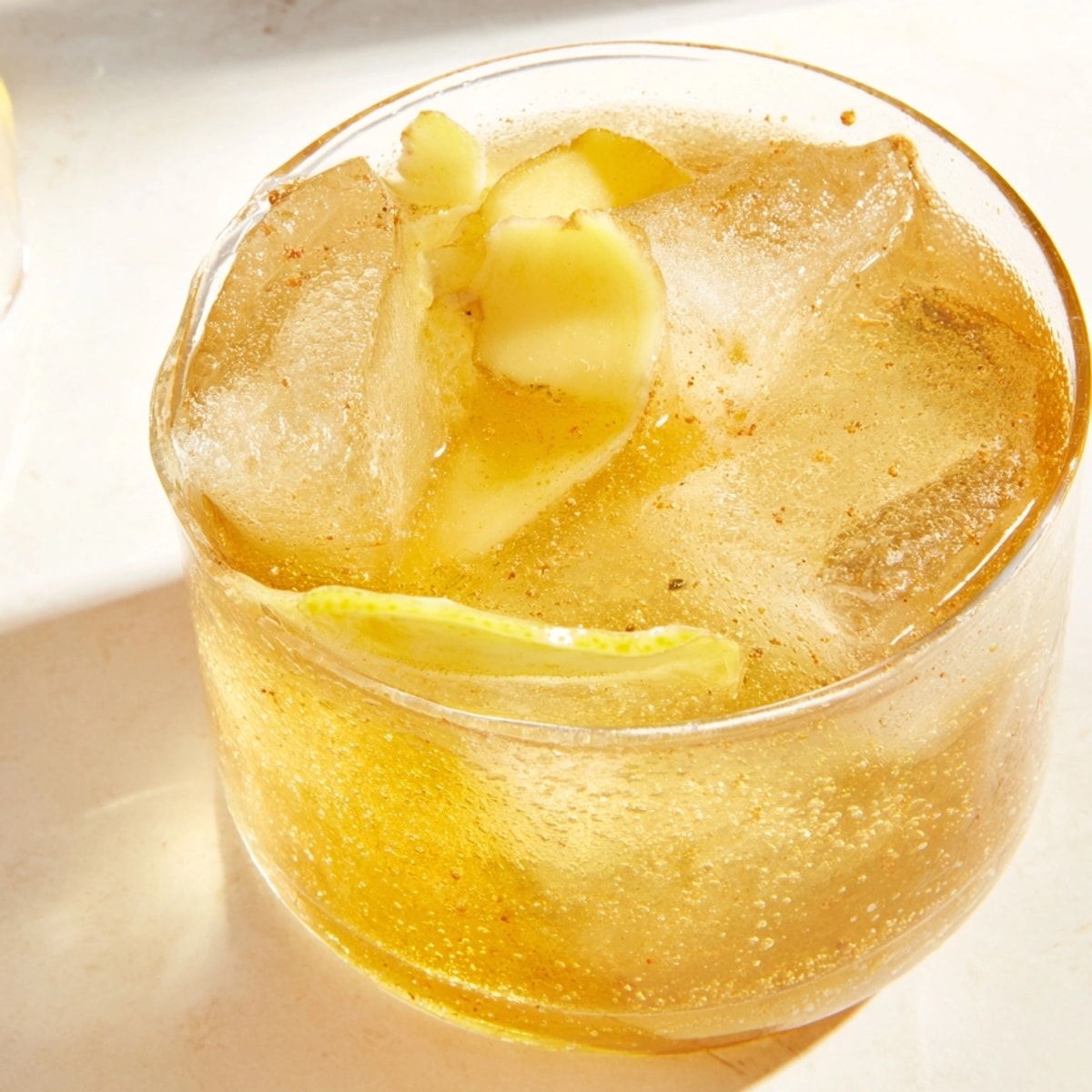 Icy cold Maple Ginger Sour mocktail in a glass, garnished with bright lemon.