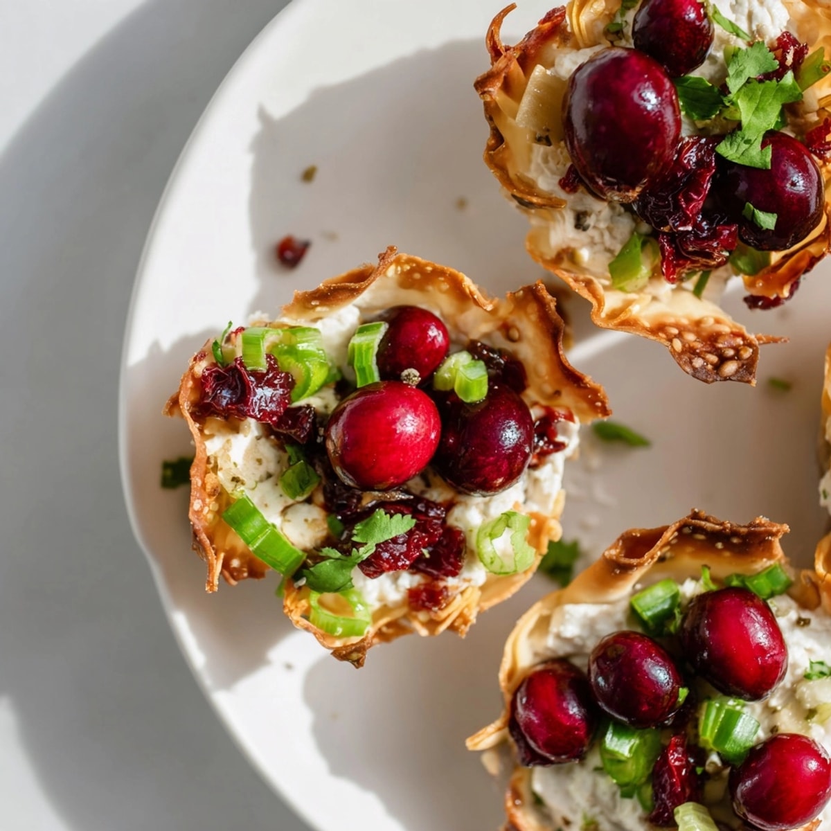 Crispy baked wonton cups overflowing with homemade cranberry jalape&amp;ntilde;o dip ready to serve.