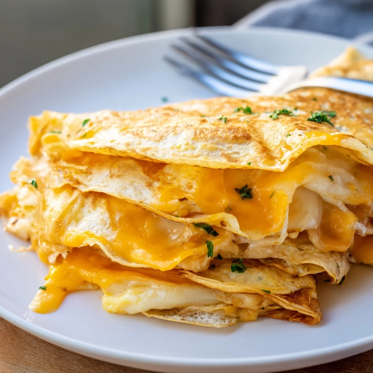 A delicious Cheesy Garlic Tortilla Omelette served with fresh herbs and melted cheese.   
