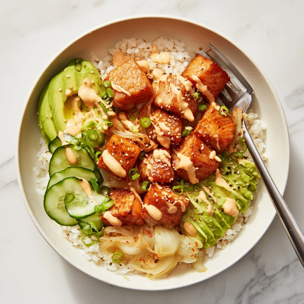 Crispy salmon rice bowl with vibrant toppings and creamy spicy mayo drizzled on top.  