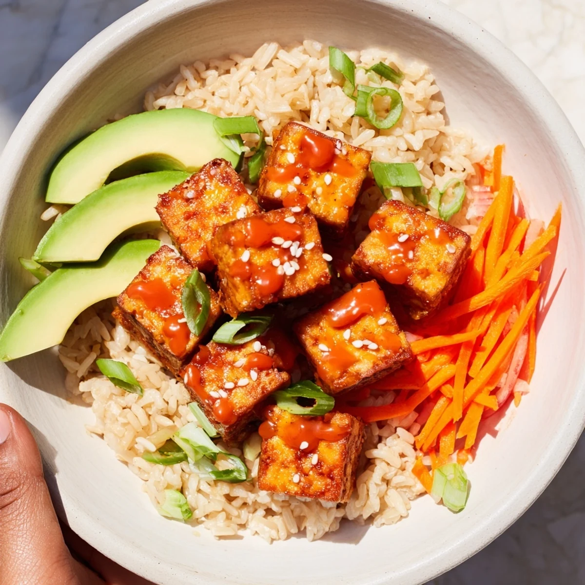 Vibrant vegetarian chili-mayo baked tofu being scooped from the bowl, ready for a satisfying bite.