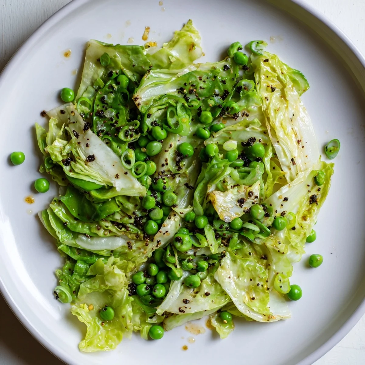 Savory Cabbage Stir-Fry featuring garlic and soy sauce with bright green peas, perfect as a vegan meal.