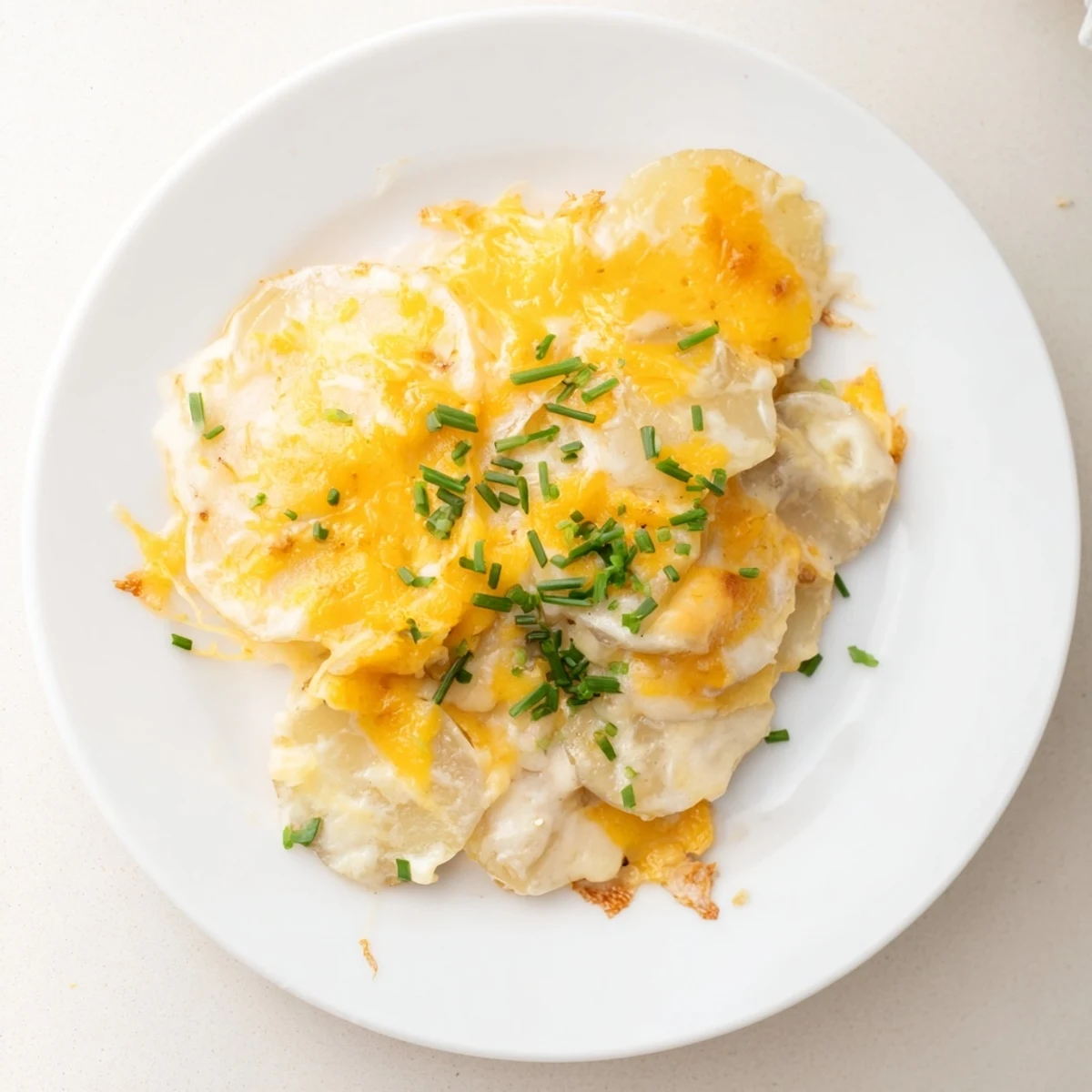 Rich and creamy Cheesy Scalloped Potatoes, layered with tender potatoes and melted cheddar cheese.