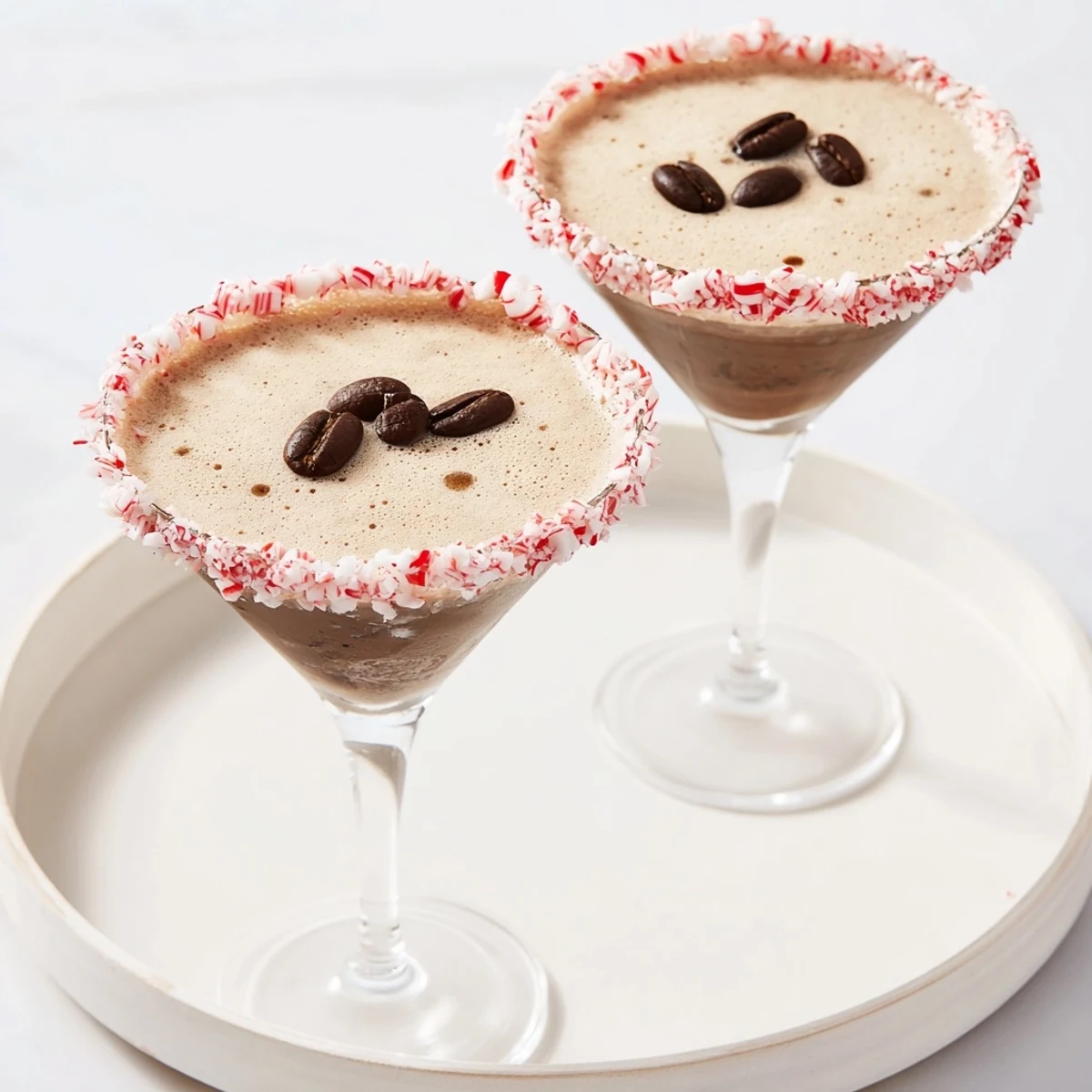 Close-up of a frothy Peppermint Espresso Martini, a holiday cocktail with crushed candy cane rim.