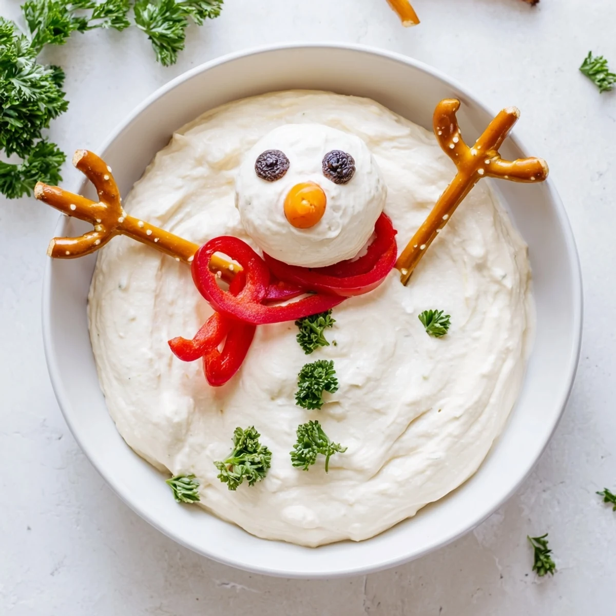 Adorable Melted Snowman Dip Bowl surrounded by colorful veggie dippers, perfect for holiday parties.