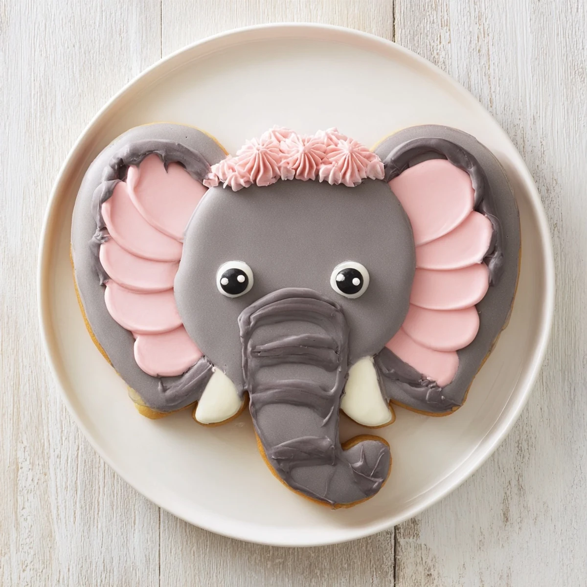 Enjoy delightful, elephant-shaped Biscuits Amical Éléphant Géant, beautifully decorated with pink and gray frosting.