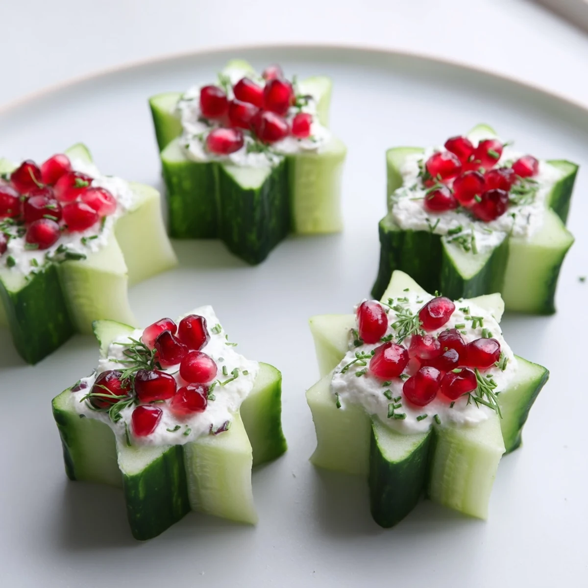 Freshly prepared Winter Salad: cool cucumber cups with colorful filling, garnished with vibrant pomegranate.