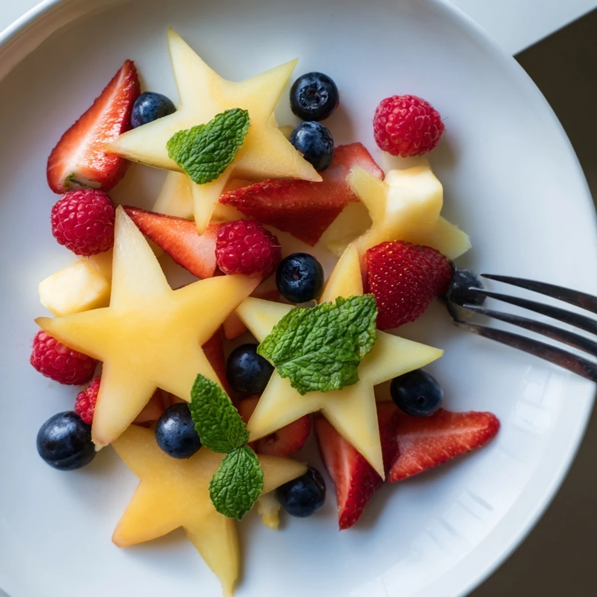 Vibrant starfruit stars paired with juicy strawberries, blueberries, and raspberries for a light dessert.