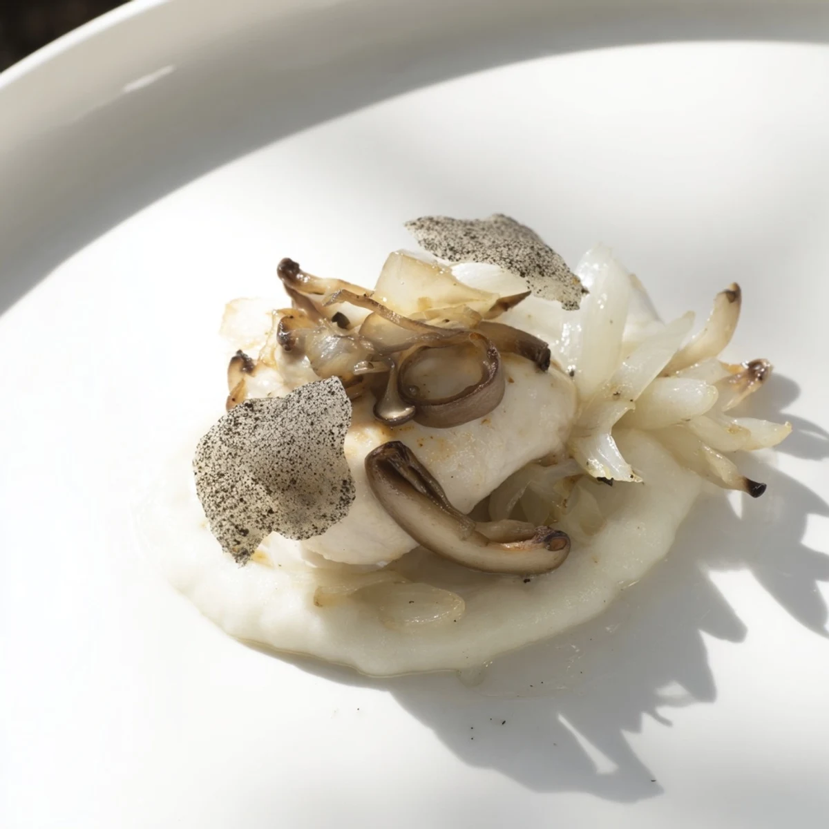 A visually striking image of The Ghostly Gala: tender chicken on creamy white cauliflower purée.