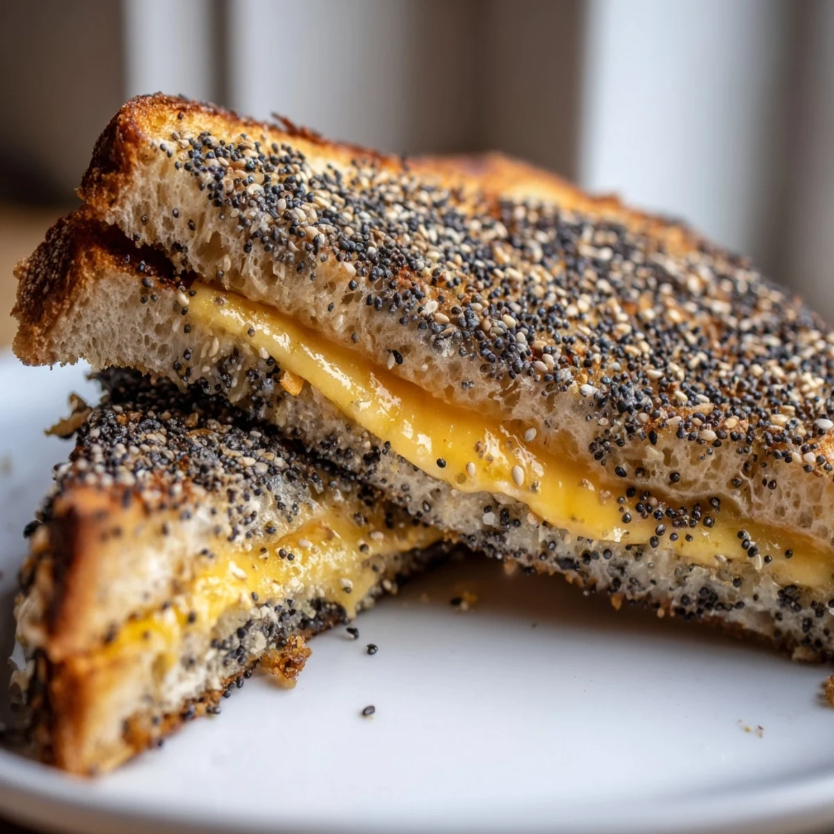 Golden-brown Everything Bagel Grilled Cheese, with melted cheddar oozing out between crispy toasted bread.