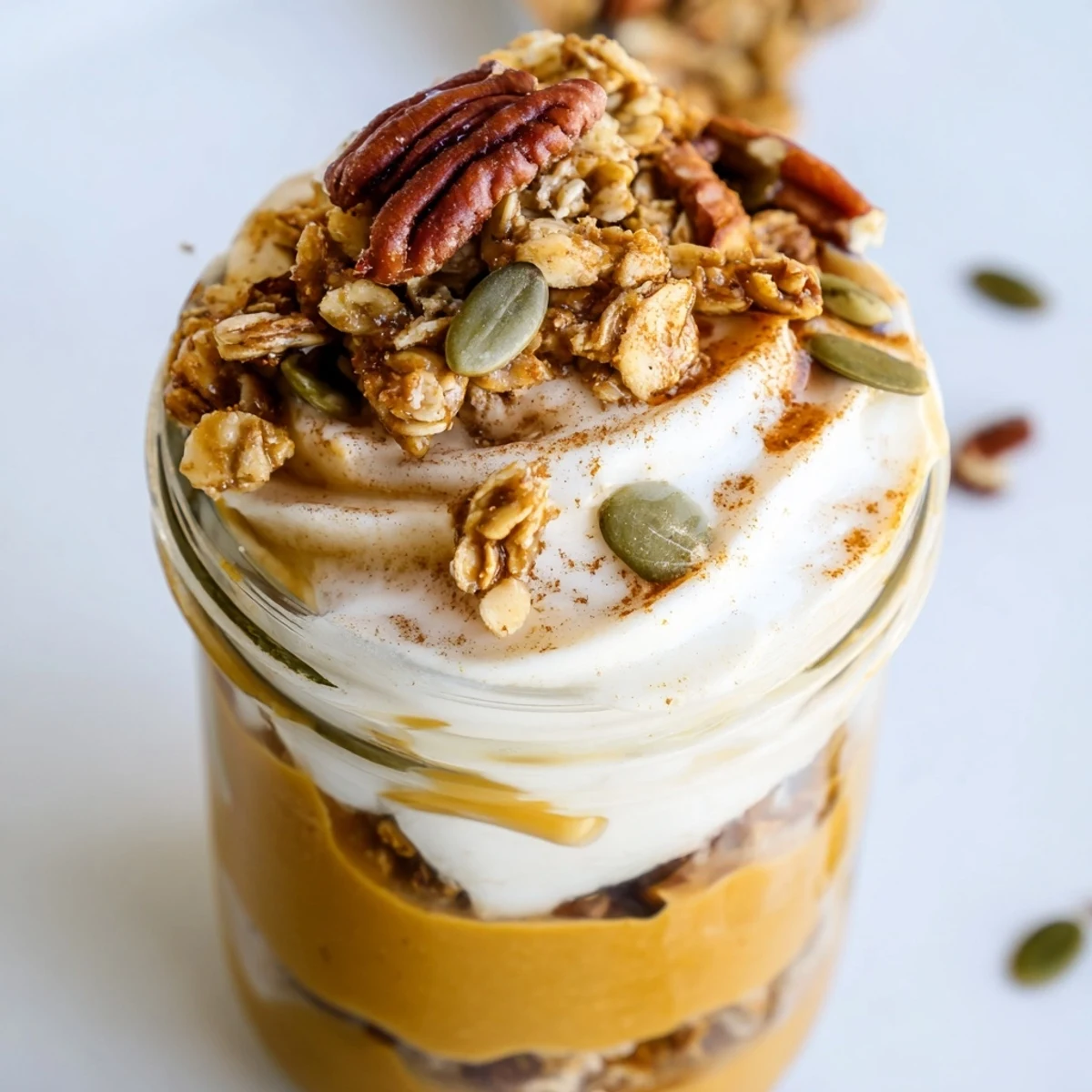 Delicious Pumpkin Yogurt Parfait layered with spiced pumpkin, creamy yogurt, and crispy granola.
