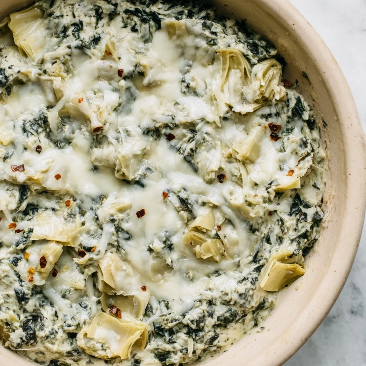 Warm and creamy Spinach Artichoke Dip, full of cheese and artichoke flavor, ready to eat.