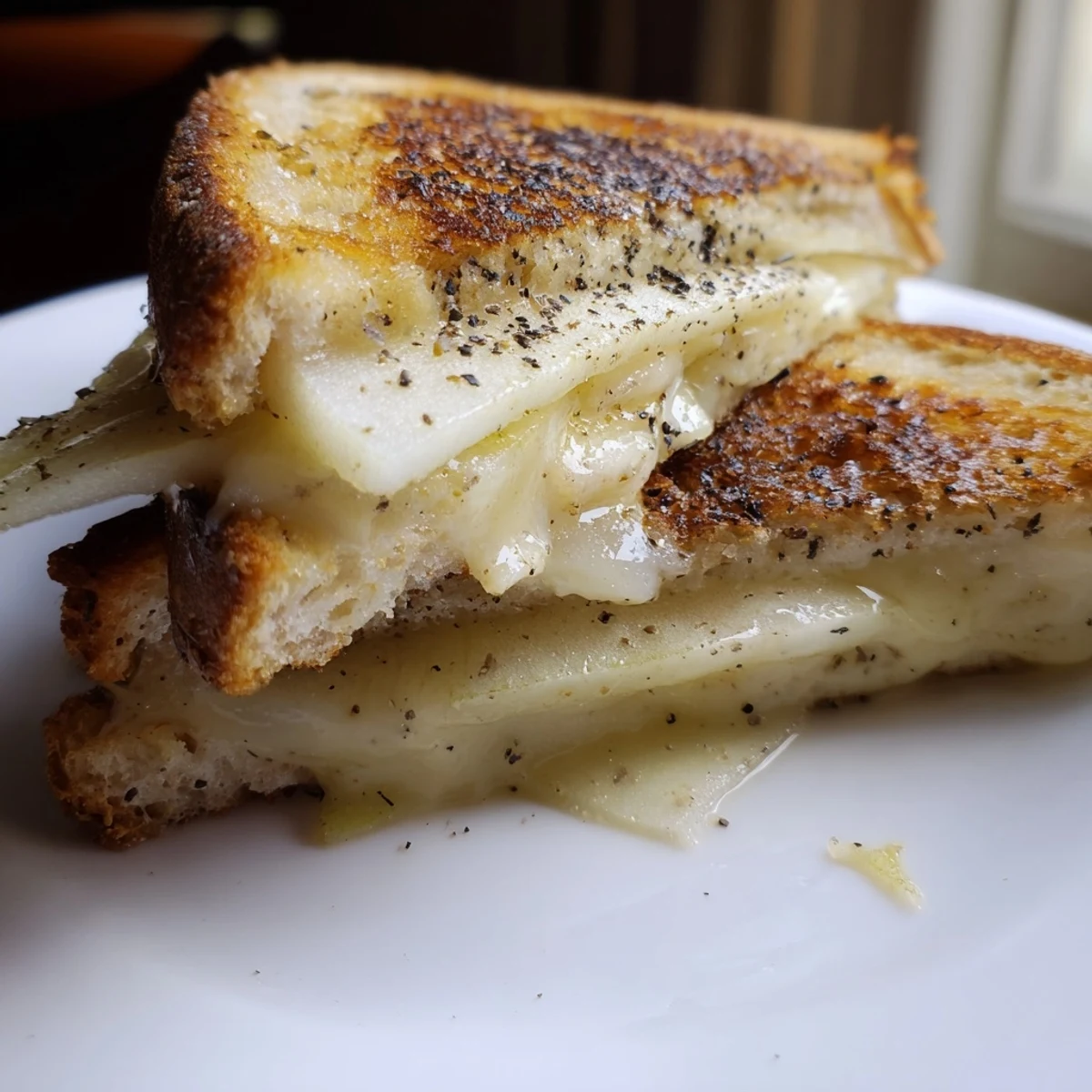 A close-up of a perfectly grilled Smoked Gouda & Apple Grilled Cheese, with melted cheese and toasty bread.