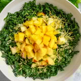 Fresh The Sunlit Glade salad showcases bright mango, pineapple, and greens, sprinkled with toasted seeds.