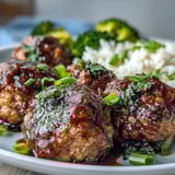 Savory Honey Garlic Turkey Meatballs glisten as they rest on jasmine rice with bright green broccoli florets.