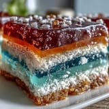 Beautifully layered Rainbow Jelly Cake dessert, glistening with coconut cream on top.