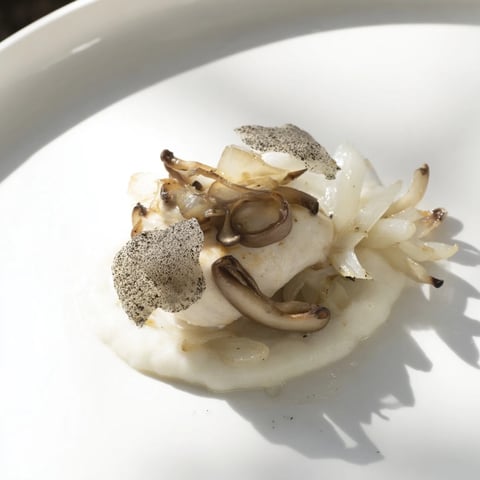 A visually striking image of The Ghostly Gala: tender chicken on creamy white cauliflower purée.