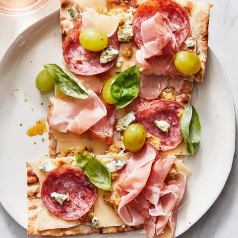 The Rustic Raft appetizer: A beautiful flatbread loaded with meats, cheeses, and fresh toppings.