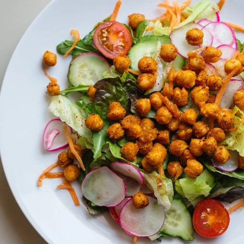 Vibrant mixed greens salad with crispy chickpea croutons, a satisfying vegan delight.