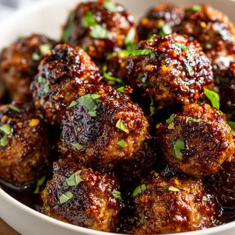 A bowl of meatballs with sauce.