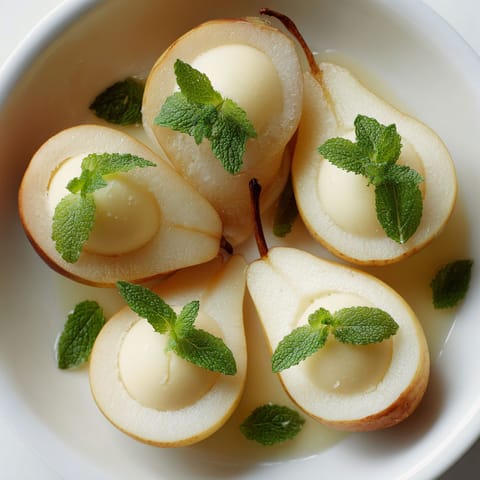 A bowl of fruit with mint leaves on top.