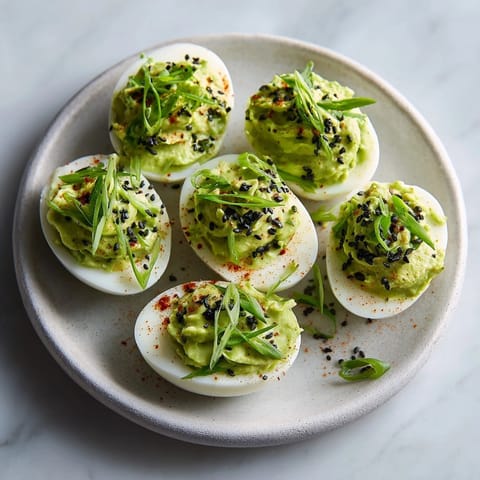 Vibrant Ghastly Green Deviled Eggs: A Halloween appetizer with spicy wasabi filling.