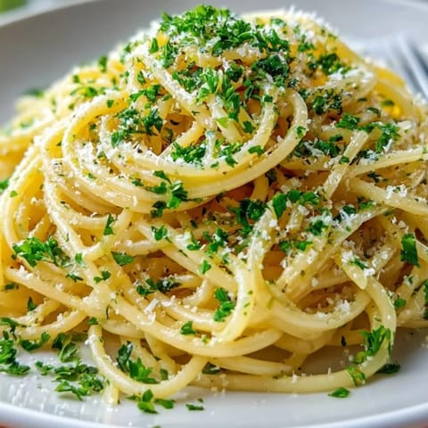 Creamy Garlic Butter Pasta with Parmesan garnished with fresh parsley &ndash; a simple Italian delight.
