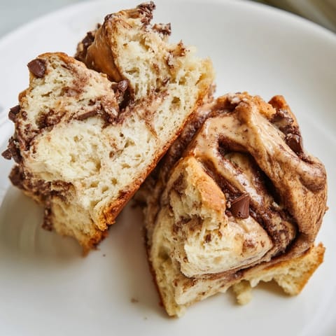 Close-up of a flaky Peanut Butter Chocolate Swirl Scone, showing peanut butter and chocolate.