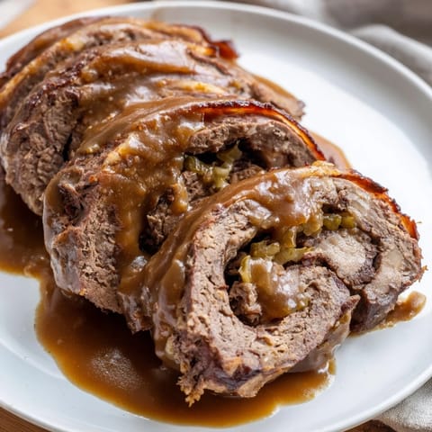 Homemade Hearty Beef Rouladen served with creamy mashed potatoes and red cabbage.  