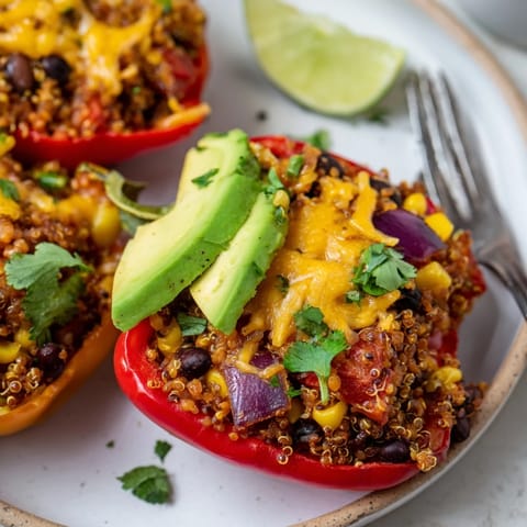Savory black bean & quinoa stuffed peppers garnished with fresh cilantro and lime.  