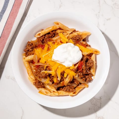 A sizzling skillet of Easy Beef Enchilada Pasta, with ground beef and flavorful enchilada sauce.