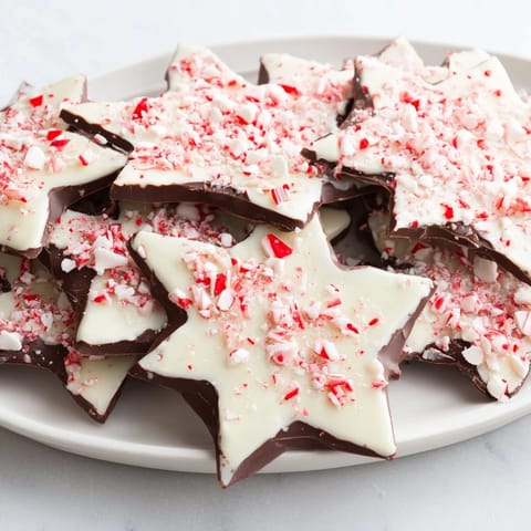 Close-up of vibrant Peppermint Bark Snowflakes: layers of chocolate topped with crushed peppermint candy.