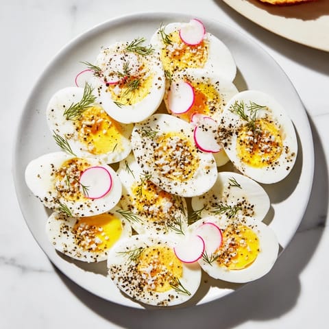 Vibrant brunch spread featuring hard-boiled eggs with everything bagel seasoning alongside fresh vegetables.