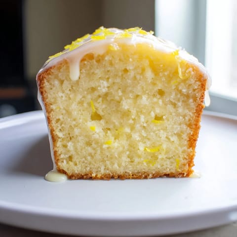Warm, freshly baked Lemon Yogurt Cake slice, showing a moist interior, perfect for a light dessert.