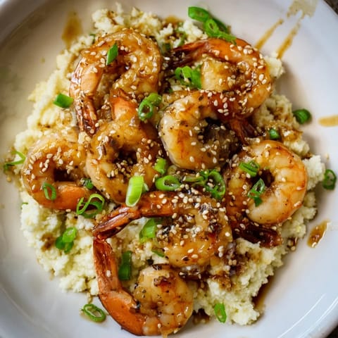 A close-up of savory ginger garlic shrimp bowls with juicy shrimp and fluffy cauliflower rice.