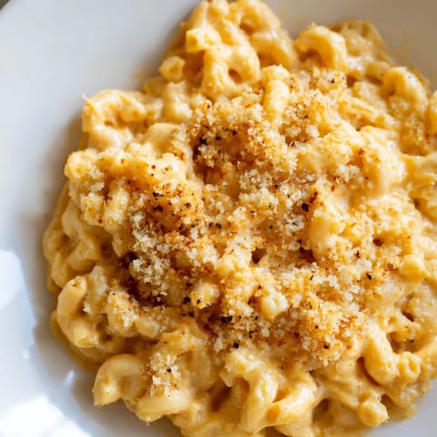 Creamy Pumpkin Mac & Cheese topped with golden breadcrumbs, ready for a comforting bite.