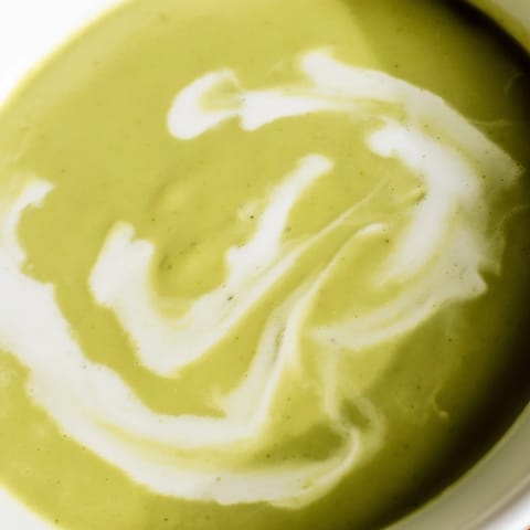 Creamy broccoli soup in a rustic bread bowl with a side of croutons, offering a cozy, comforting meal for chilly days.