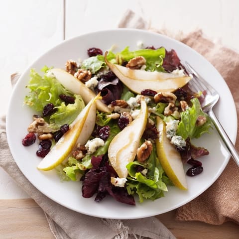Pear Gorgonzola Salad served as a light meal, featuring colorful greens, tangy cheese, sweet pear slices, and crunchy toasted walnuts.