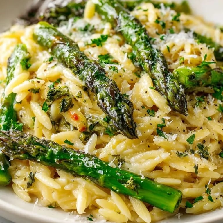 Golden Lemon Butter Orzo with Asparagus swirls in a bowl, ready to eat.