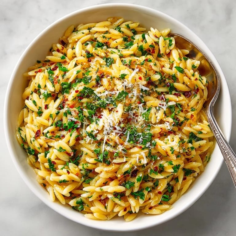 Enjoy warm, comforting Herb-Roasted Garlic Orzo, speckled with herbs and roasted until golden.