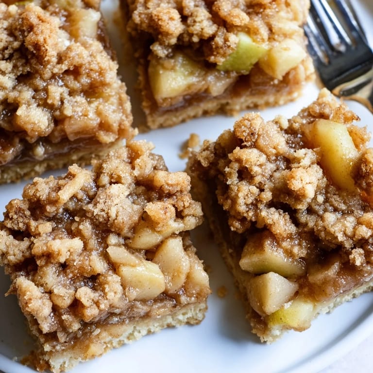 Warm Dutch apple pie squares topped with buttery crumbs, ideal with vanilla ice cream.  