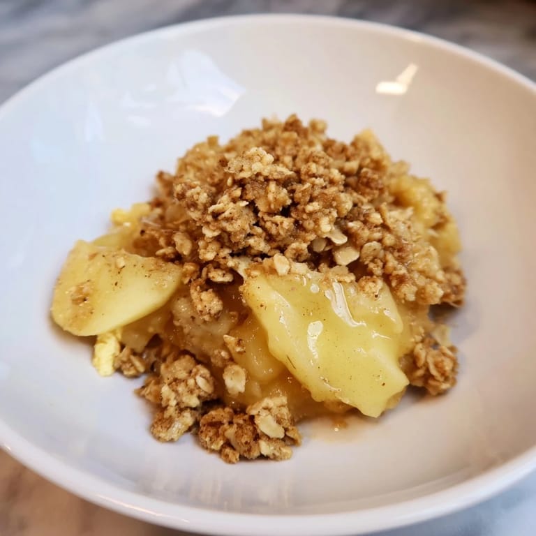 Close-up of freshly baked Best Apple Crisp, showcasing the cinnamon-spiced apple filling and crumble.