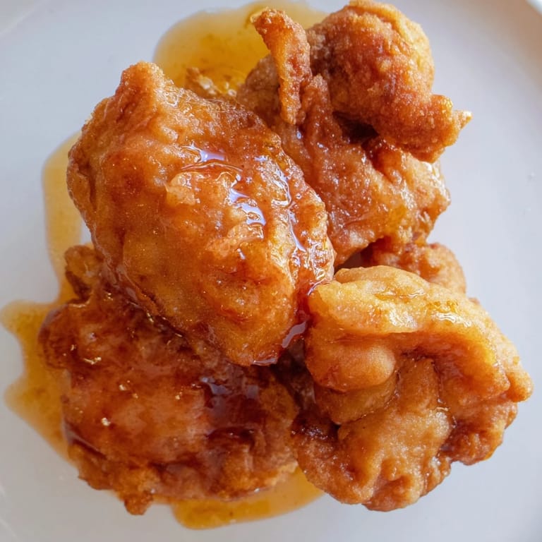 A close-up of crispy Hot Honey Butter Chicken, showing a perfect combination of sweet and spicy flavors.